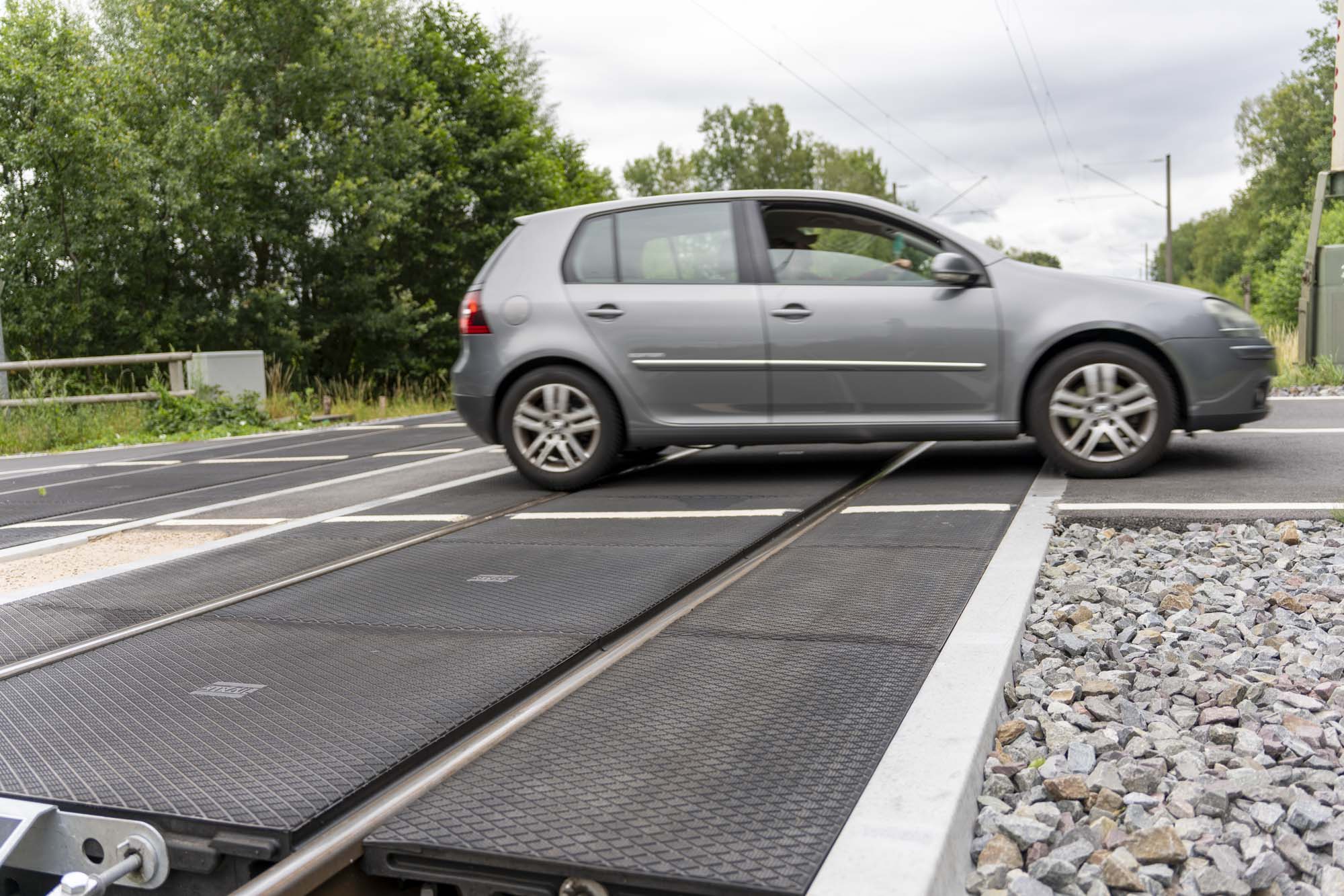 B kerbstone in a level crossing with car